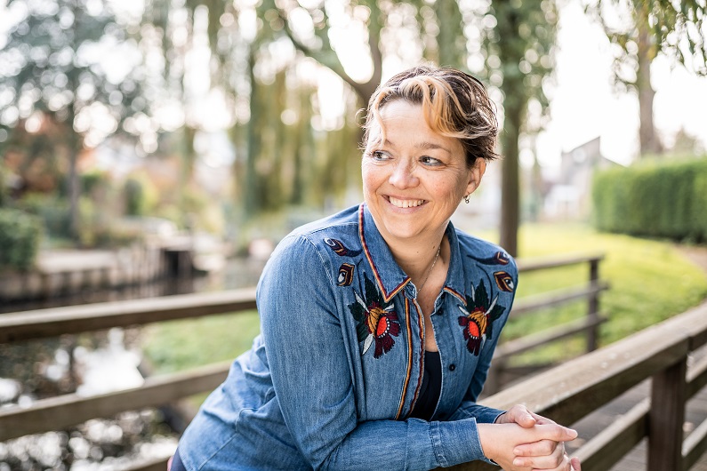 portret astrologisch coach Miranda Molenaar leunend over een bruggetje in de natuur